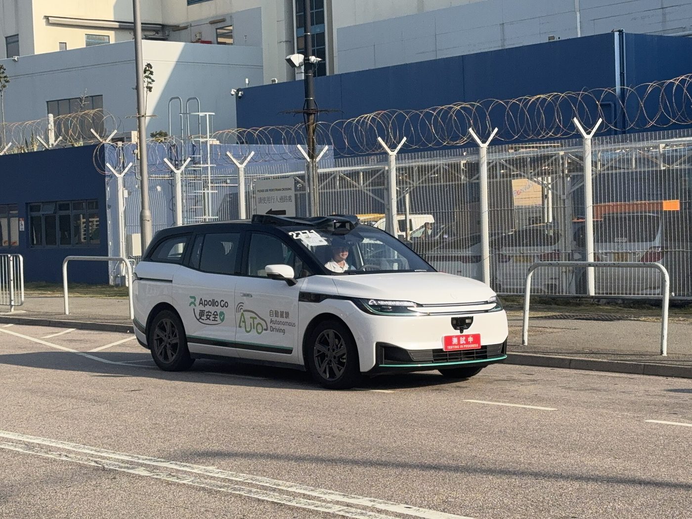 An Apollo Go autonomous test vehicle with a backup operator at the wheel near an aircraft maintenance area in Hong Kong in November 2025. File photo.