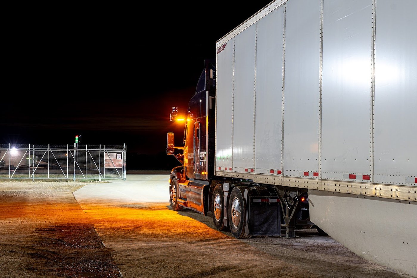 A truck's cab-mounted amber warning beacon lit at night, in an image Aurora published with its October 2025 announcement of the first federal beacon waiver.