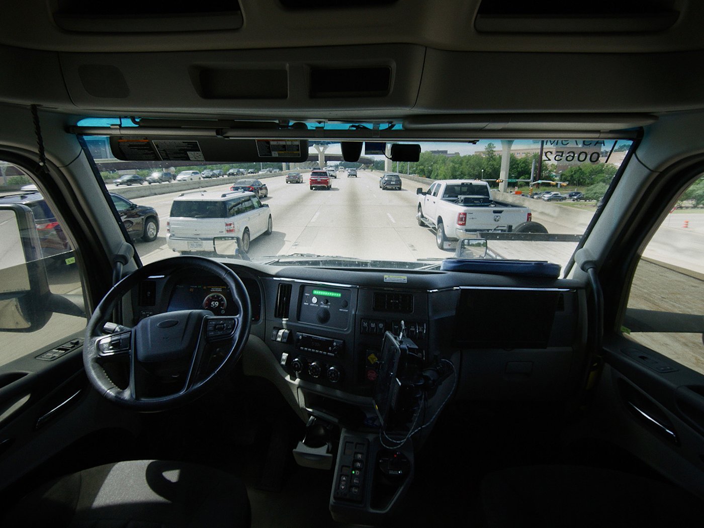 The empty driver's seat inside an Aurora self-driving truck on a highway, in a press image published by Aurora.