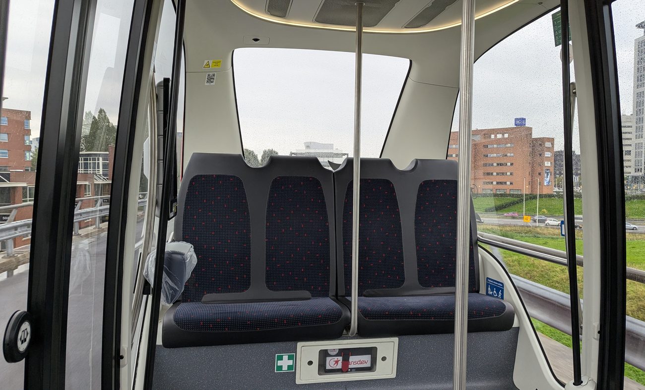 Bench seats and grab poles, but no driver's seat, inside a ParkShuttle at Rivium in Capelle aan den IJssel in September 2026.