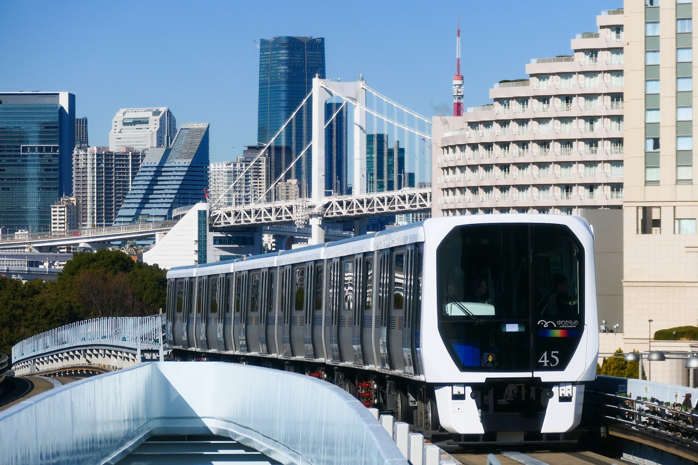 A Yurikamome 7300 series automated train on the elevated guideway near Tokyo's Rainbow Bridge.