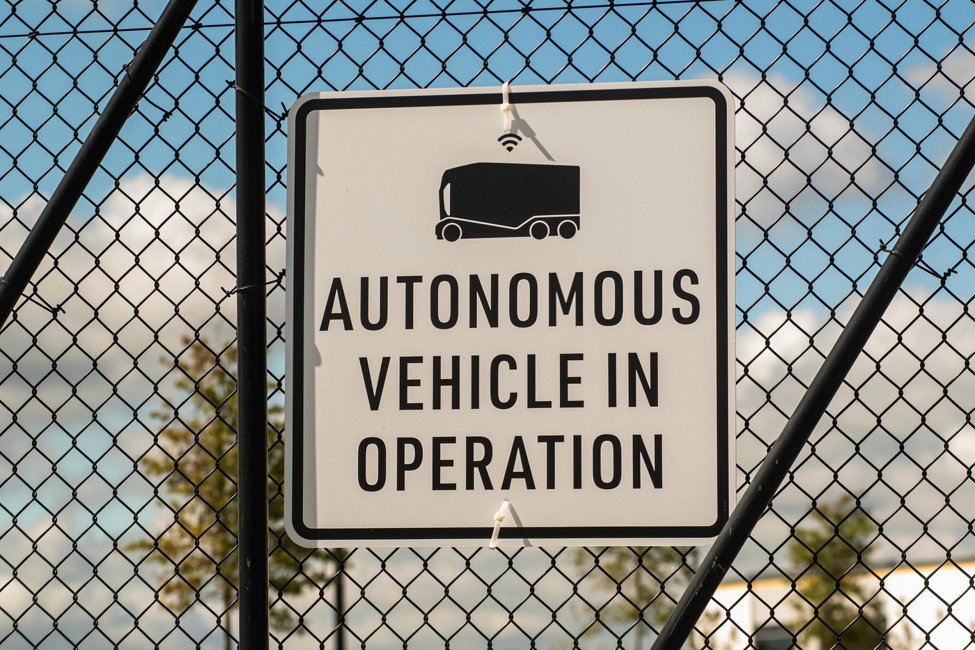 An "Autonomous vehicle in operation" sign on a fence, in a photo Einride released with its announcement of the Marysville deployment.