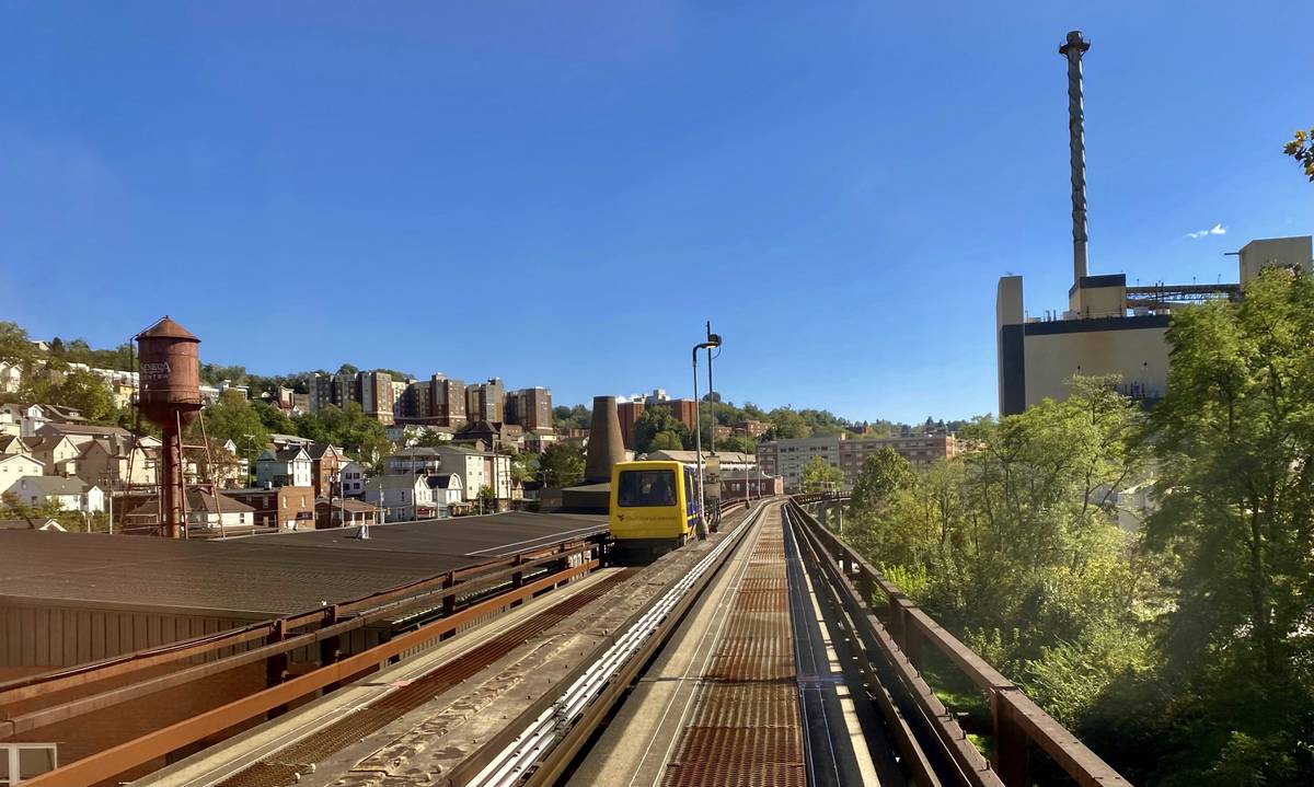 A yellow Morgantown PRT vehicle on the elevated dedicated guideway.