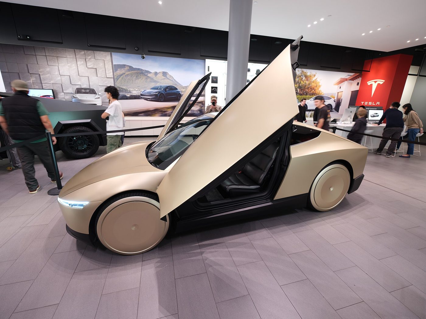 A gold Tesla Cybercab parked at Santana Row in San Jose, Calif., seen from the front quarter.