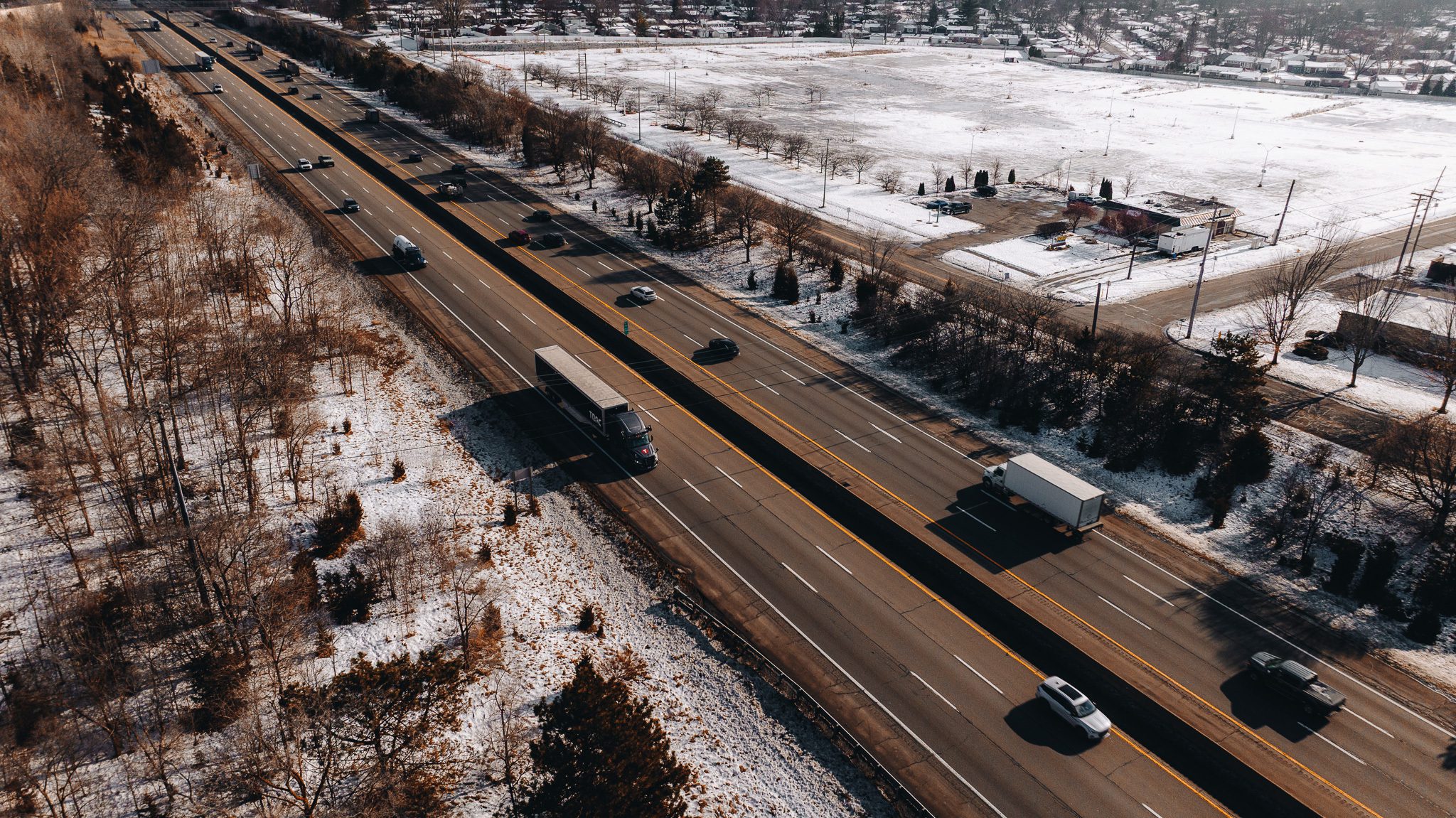 Aerial view of a Torc tractor-trailer on a multi-lane highway in winter.