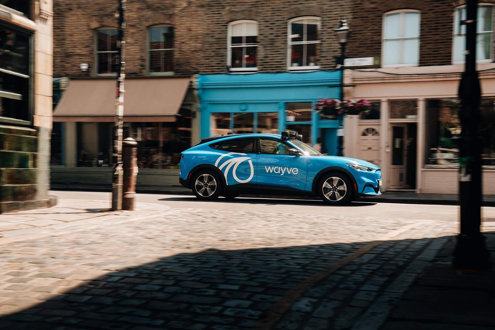 A Wayve Ford Mustang Mach-E parked on a cobbled London street.