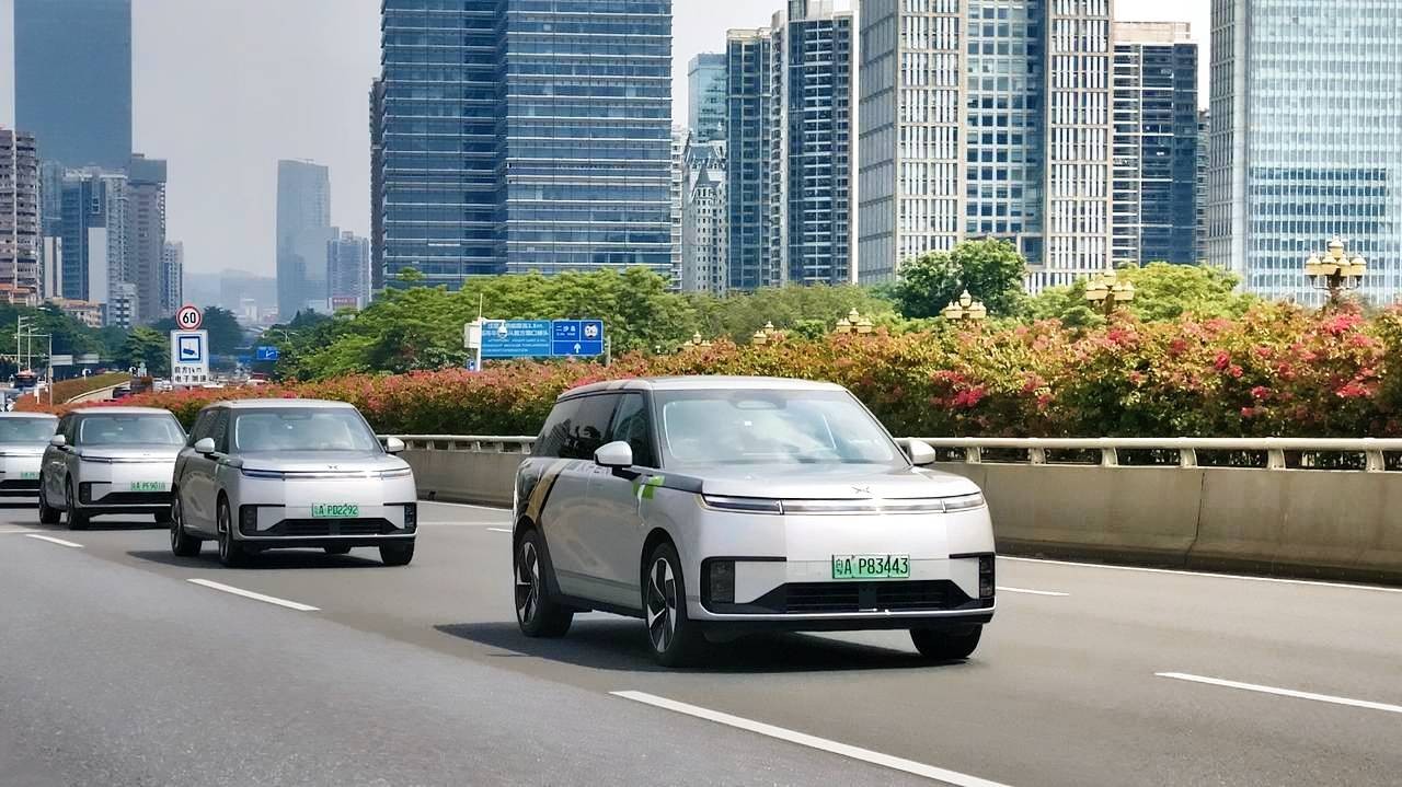 Three XPENG robotaxi vehicles on a public road in China.