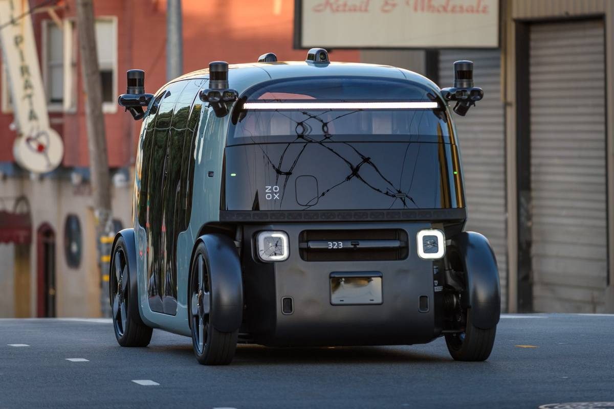 A Zoox robotaxi faces the camera on a San Francisco street.